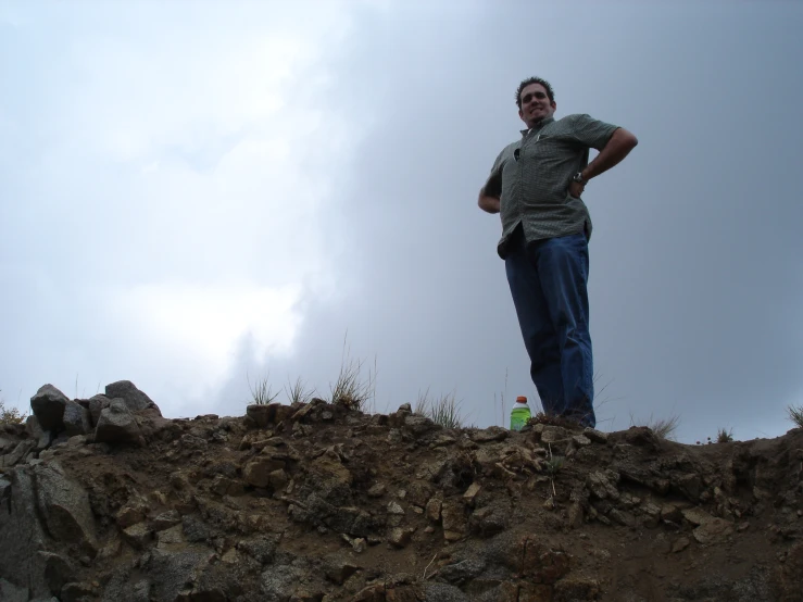 a man standing on the top of a dirt hill