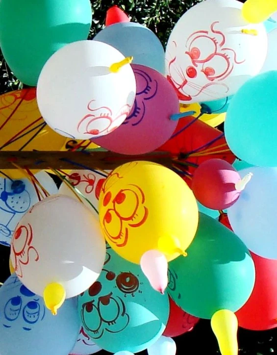 some balloons hanging on a pole near a tree