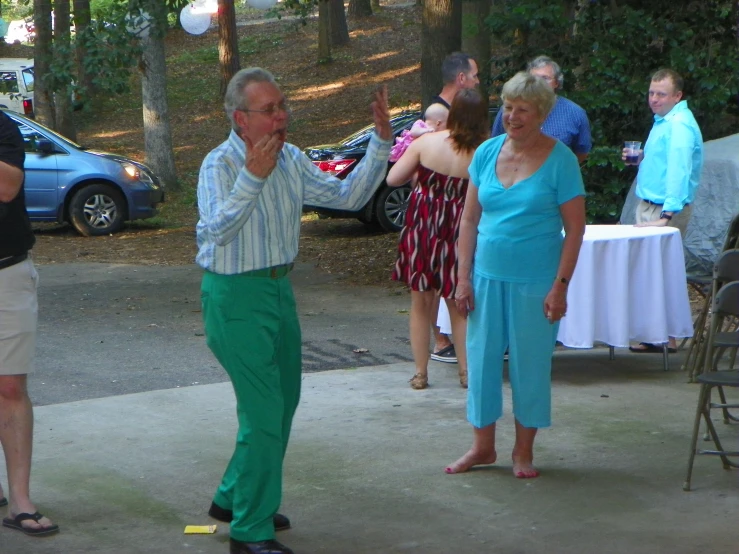 man in green pants tossing a ball at a party