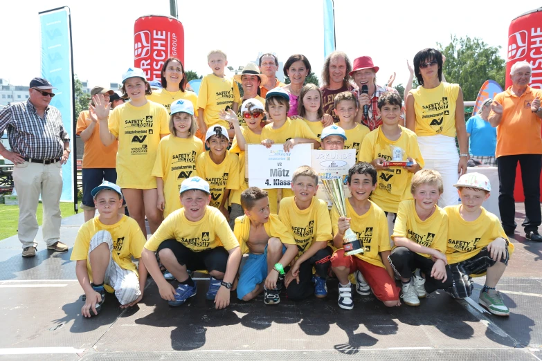 a group of children wearing yellow shirts and posing for a picture