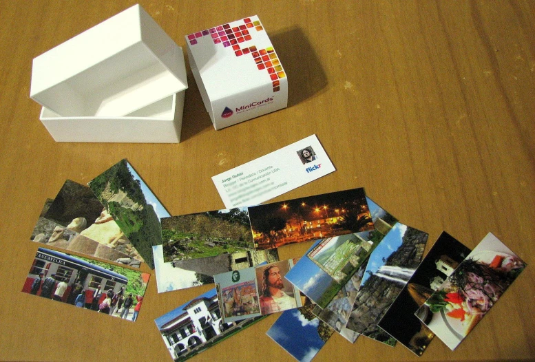 various business cards and pictures are spread out on a table