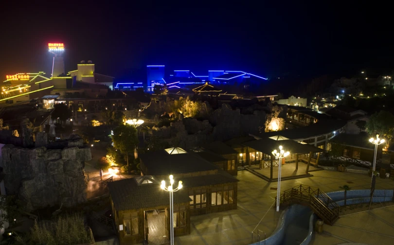 a small town has a lit up building in the background