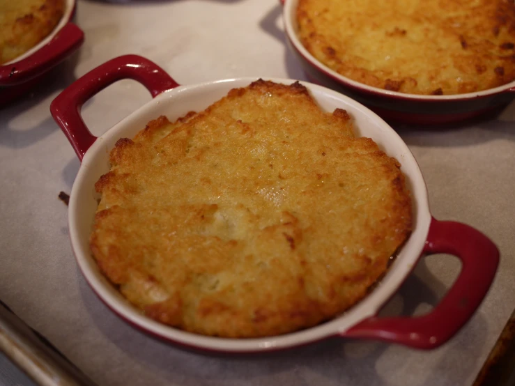 several small dishes of baked food with handles