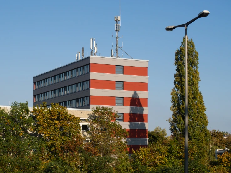 a building sits next to some trees with a television antenna on top