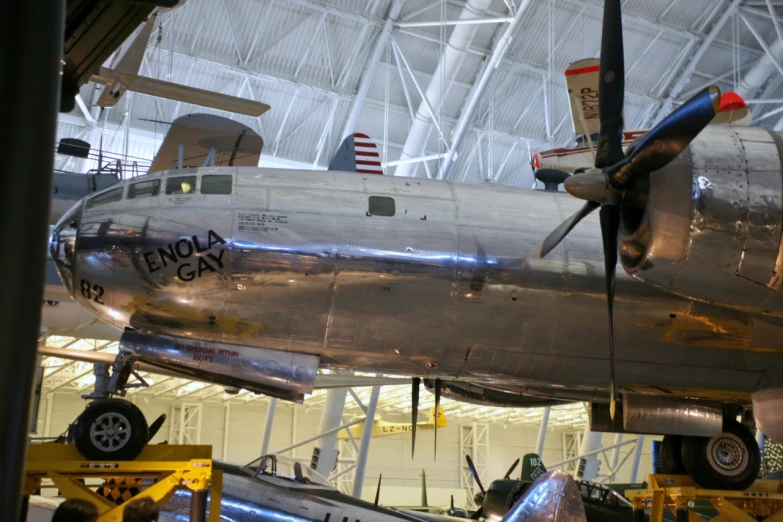 there is a silver airplane on display inside the hangar