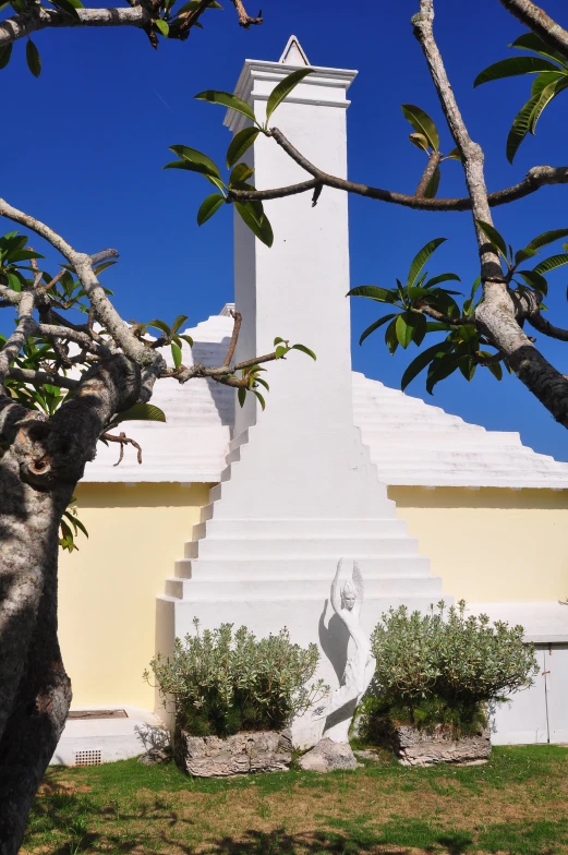 the large white tower is behind some trees