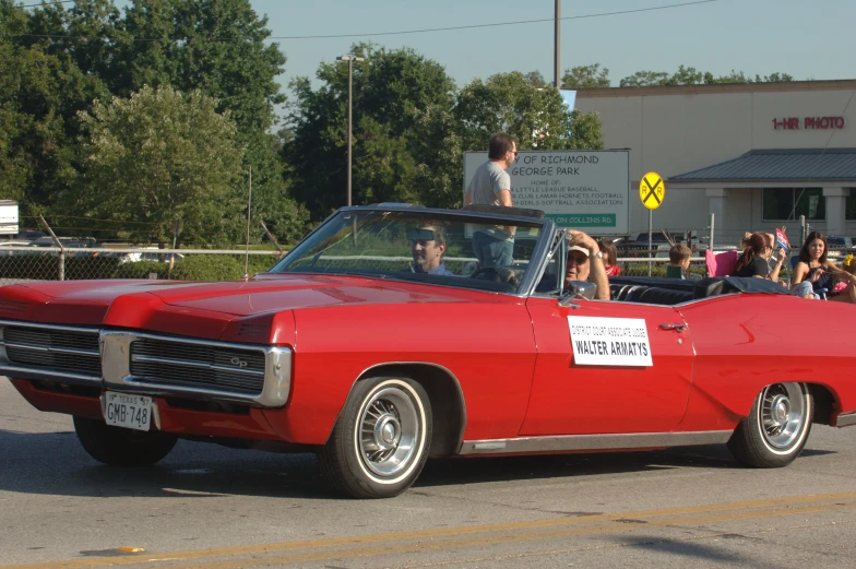 a car with people in the back riding down a street