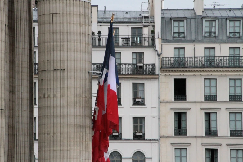 a flag flying in front of some very tall buildings