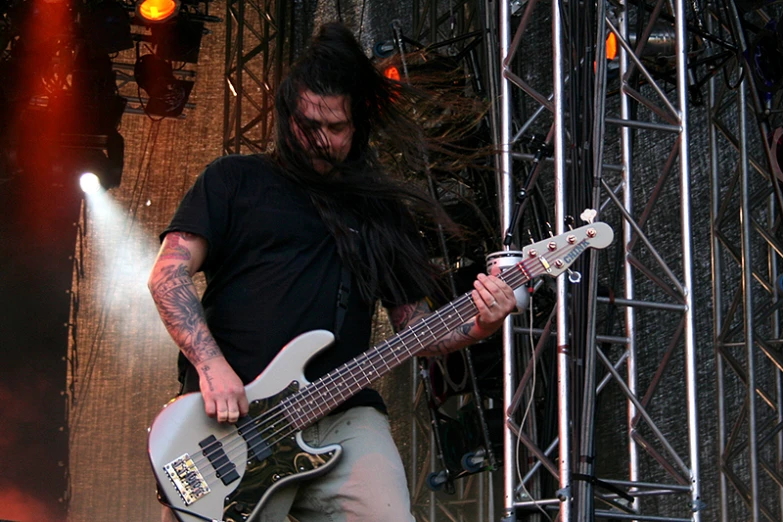 a man playing bass guitar while standing on stage