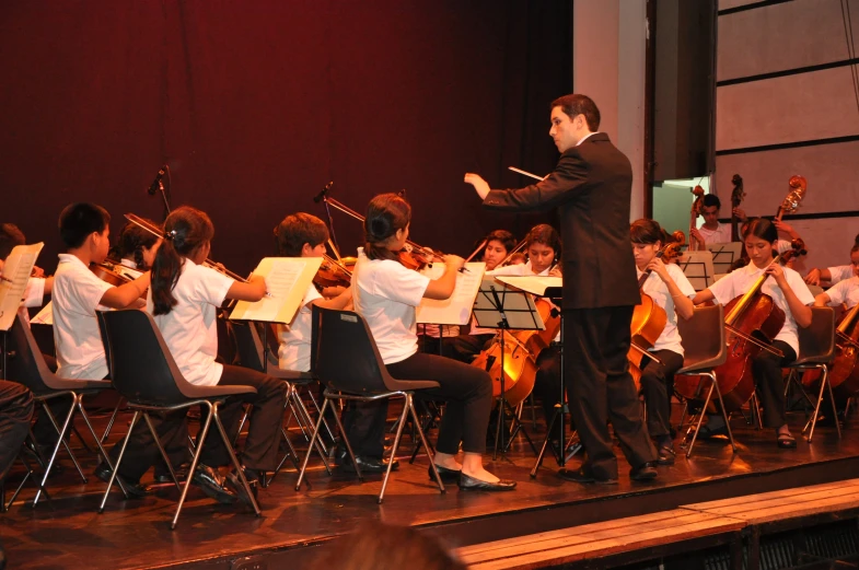 a conductor directing a band on a stage