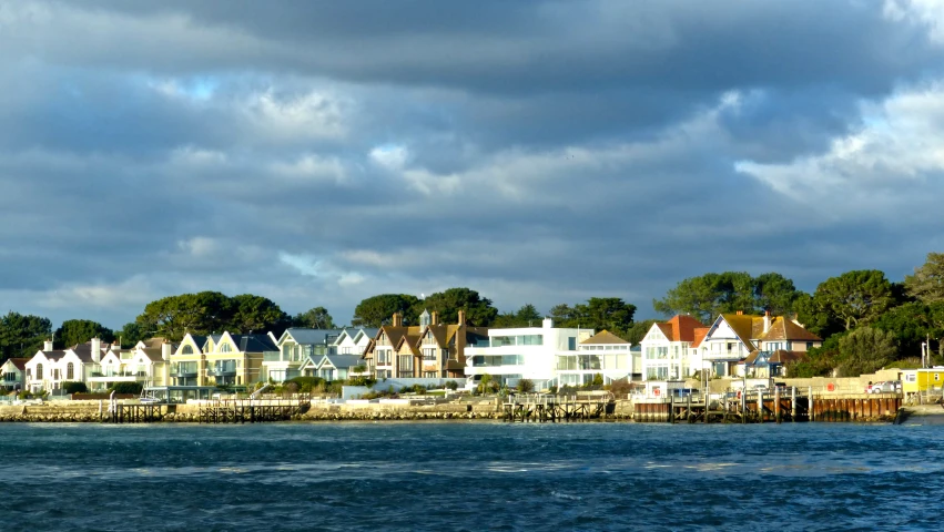 the coast line houses are shown under a cloudy sky