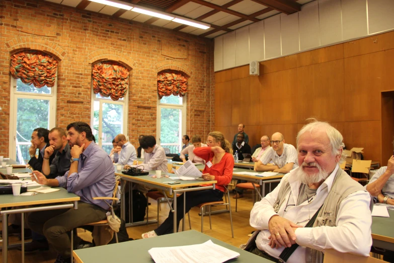 many people sitting in different chairs in a classroom