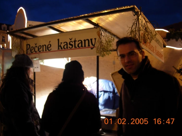 two people standing outside of an ice cream vendor