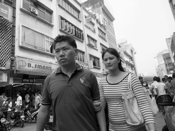 an asian man and woman walking down a street