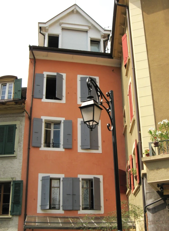 a tall building with windows has many shutters on the outside