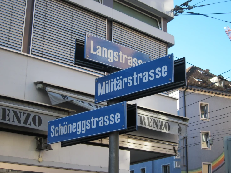 blue street signs with buildings in the background