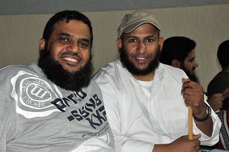 two men are smiling while holding each other