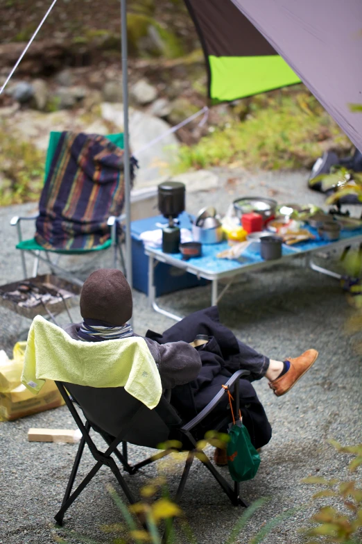 man sitting in a chair under an umbrella looking out over the water