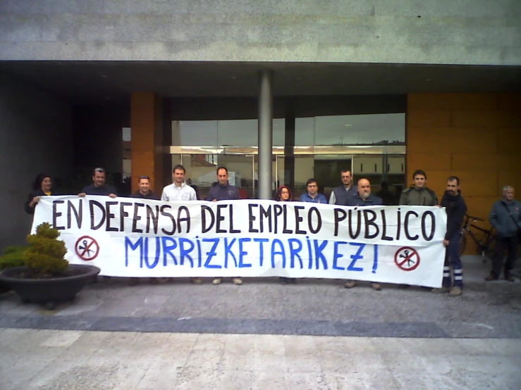 a group of people holding up a banner that says, no to imppeling public workers