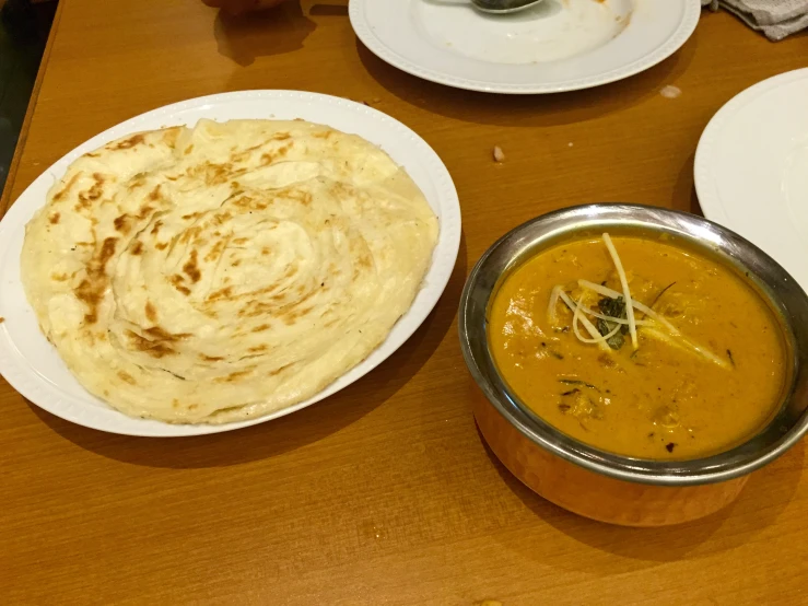 hummus and tortilla served on plates at a restaurant