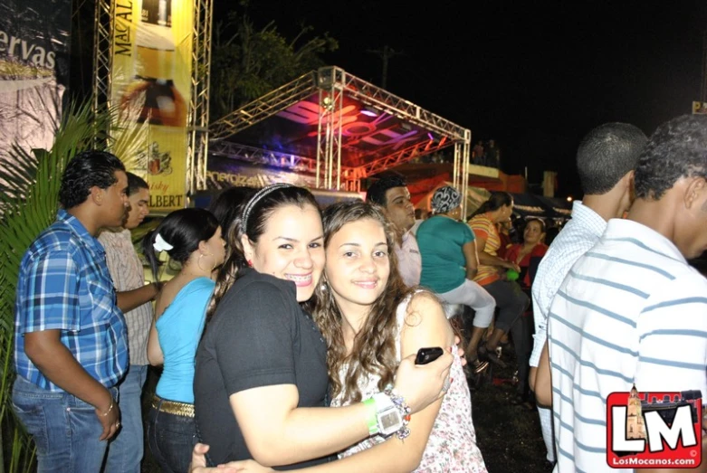 two girls hugging each other at an outdoor event
