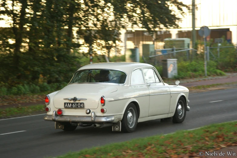 a car drives down a road near a grassy area