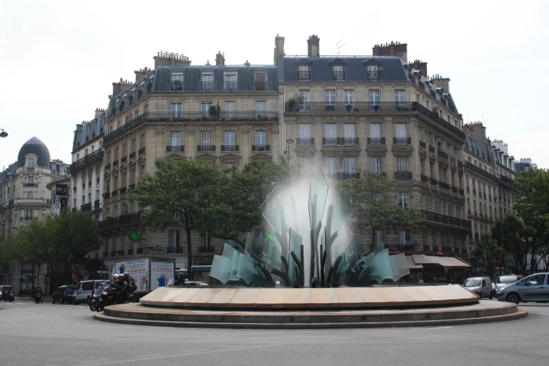 some people walk by a fountain with a castle in the background