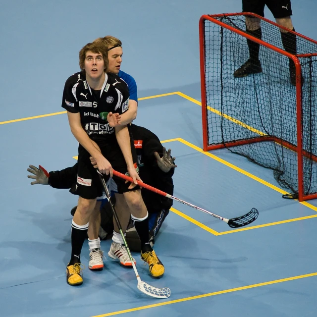 two men playing a game of indoor hockey