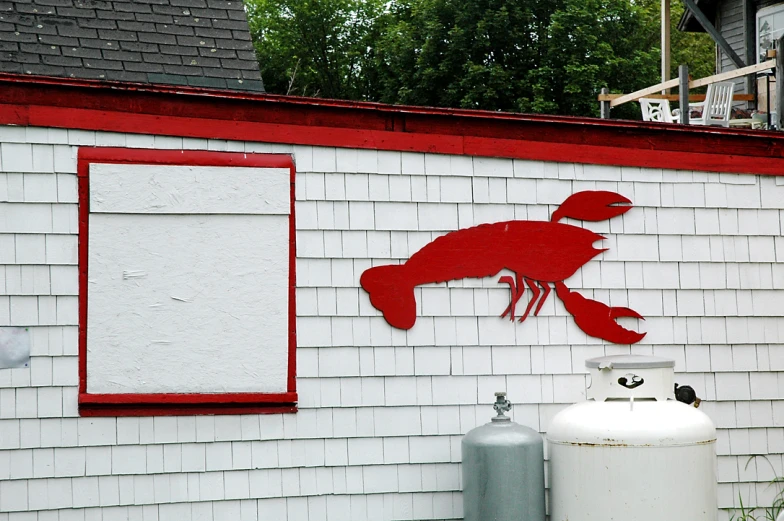 a fish painting is mounted on the side of a house