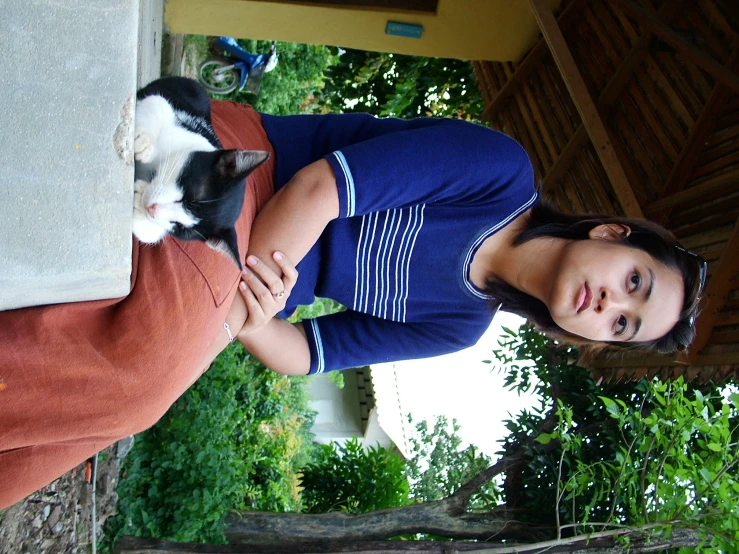 a woman is holding her cat inside the house