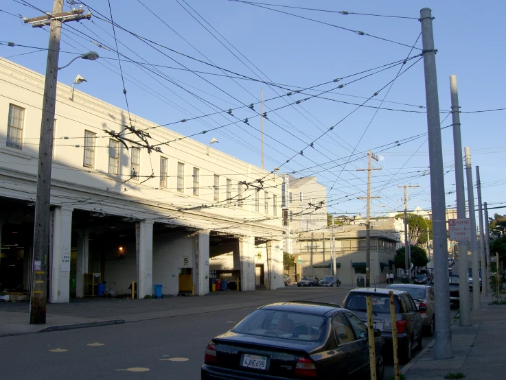 a car parked in front of a building with power lines above