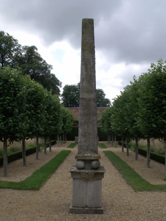 a large obelisk on a gravel driveway