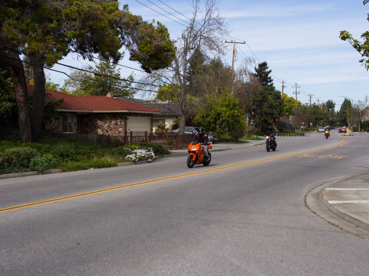 a group of people on motor bikes riding down a road