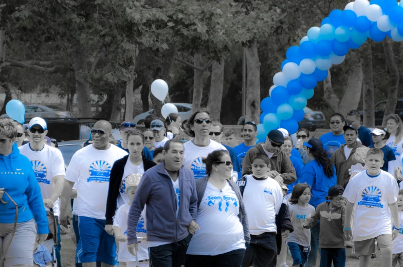 people are standing behind blue and white balloons