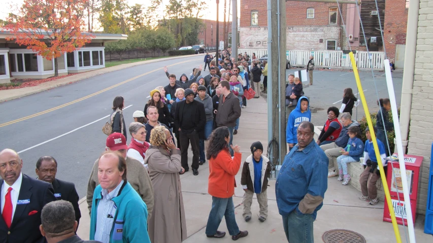 many people lined up outside a building in a line