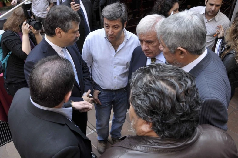 a group of people standing around each other in front of a building