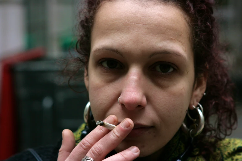 a woman with black eye makeup has two silver rings