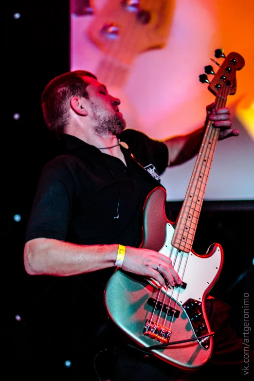 a guy holding a musical instrument on stage