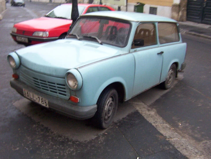 a blue car sitting next to another red one