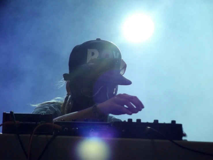 a woman in a baseball cap on stage with sound equipment