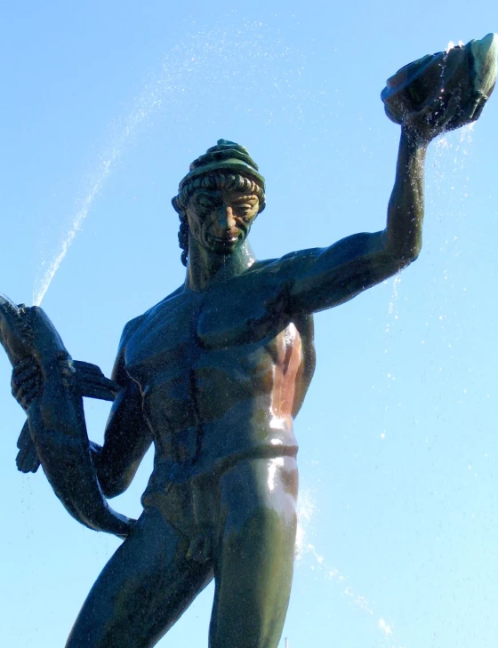 a statue holds a hat and throws up water