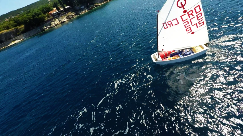 a white boat with red lettering is on the water