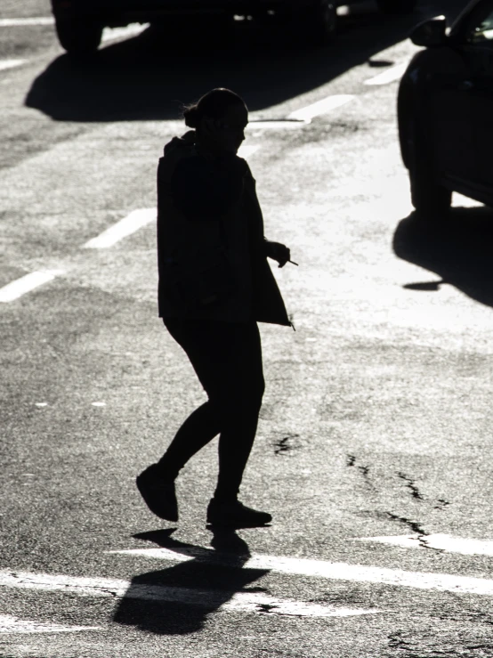 a woman crossing the street at a crosswalk