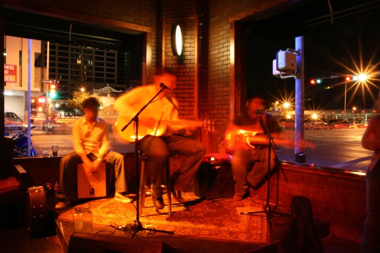 a group of people sitting on a porch with a musical instrument