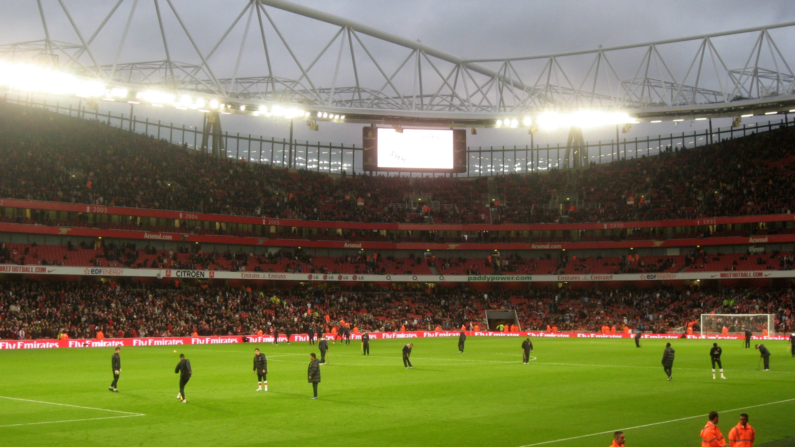 soccer players are on the field in front of an empty stadium