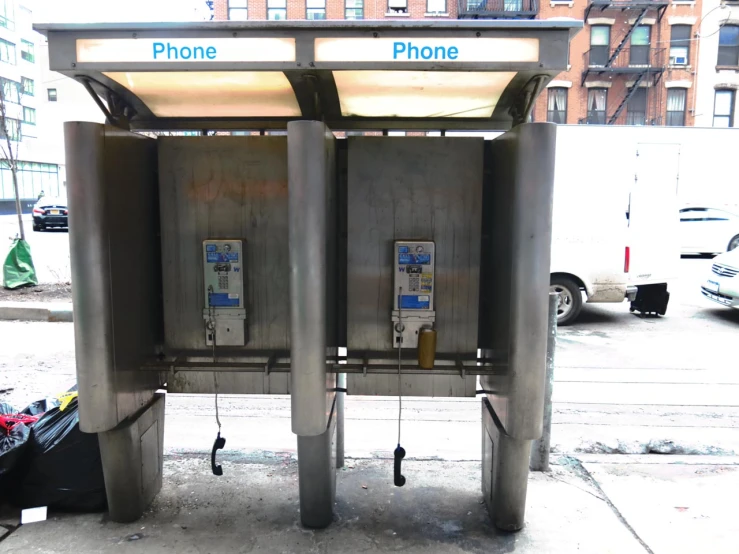 two cell phones are on the sidewalk