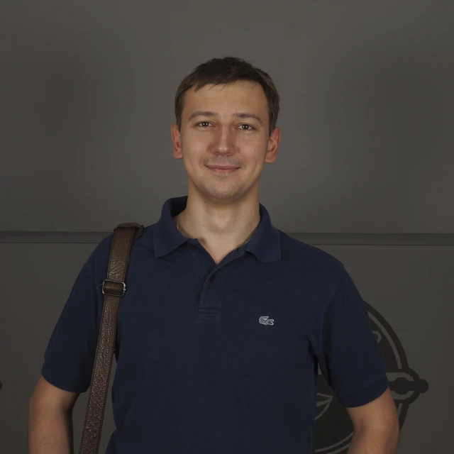 a man wearing a polo shirt and shoulder bag