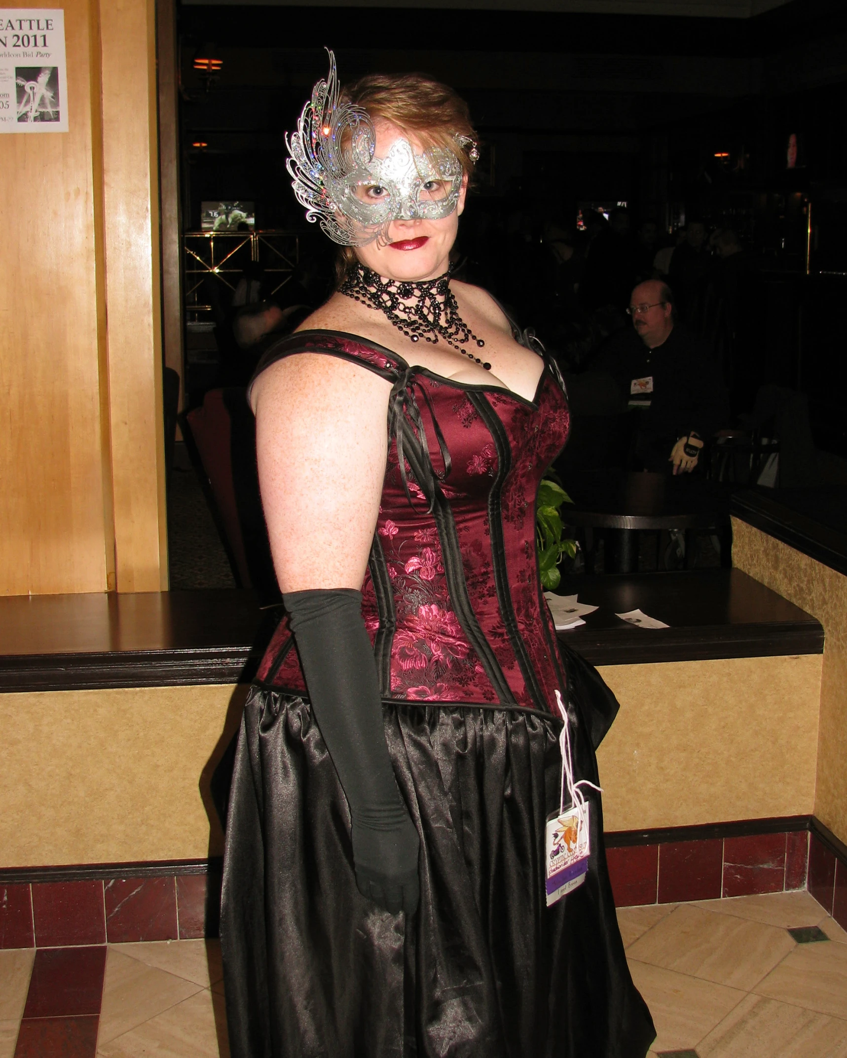 a woman in an old - fashioned red dress wearing a mask