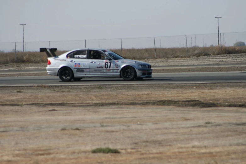 a car racing on an asphalt track with poles