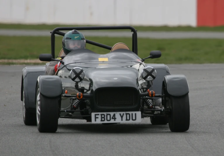 an older style race car driving down a track